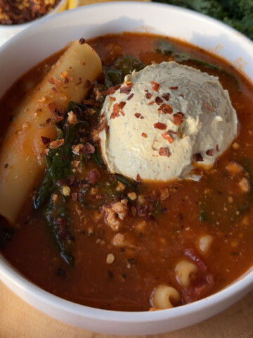 A bowl of vegan lasagna soup topped with tofu ricotta.
