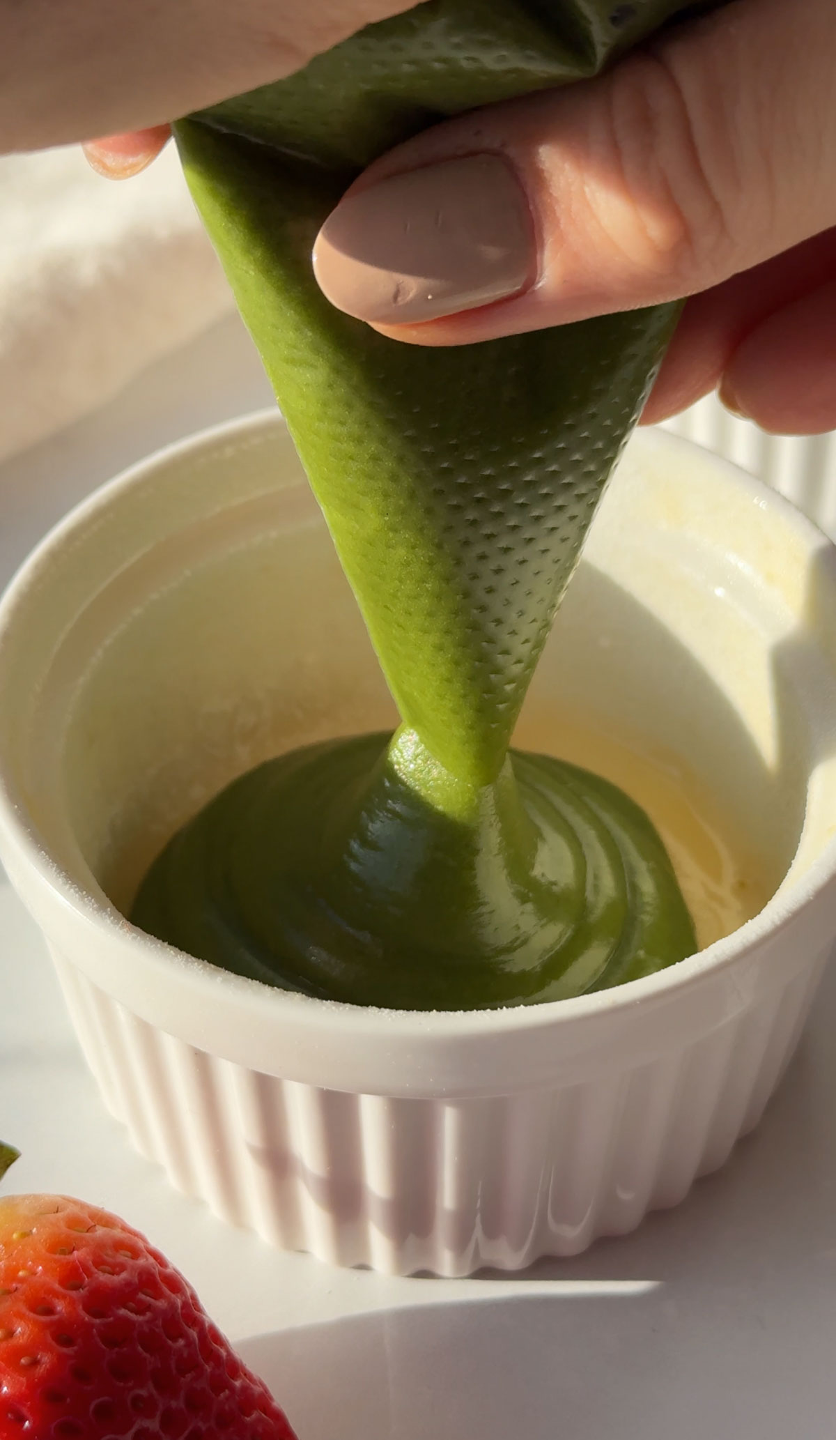 Adding the cake batter to a ramekin.