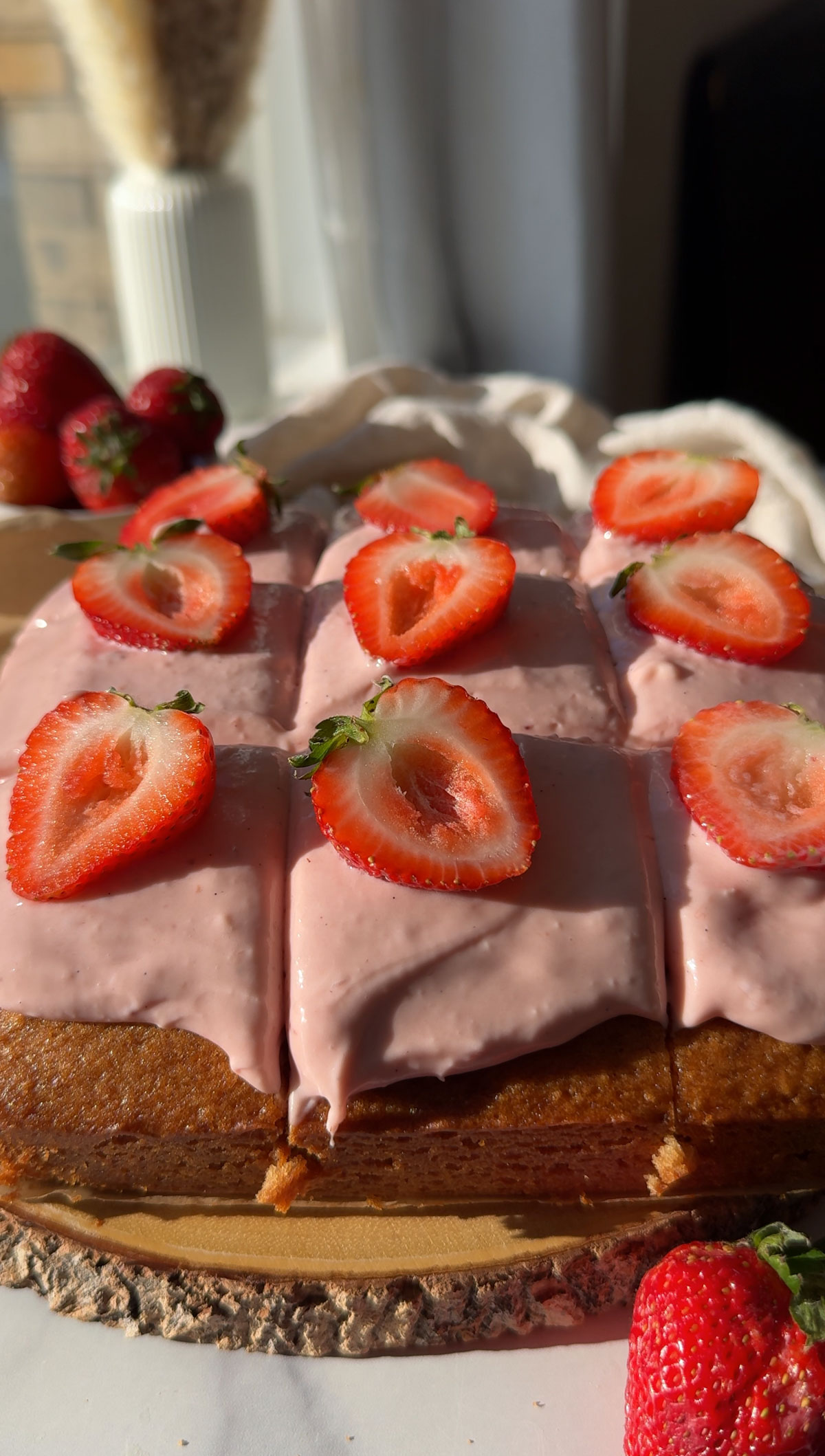 Cut into slices and berries on top of vegan strawberry cake.