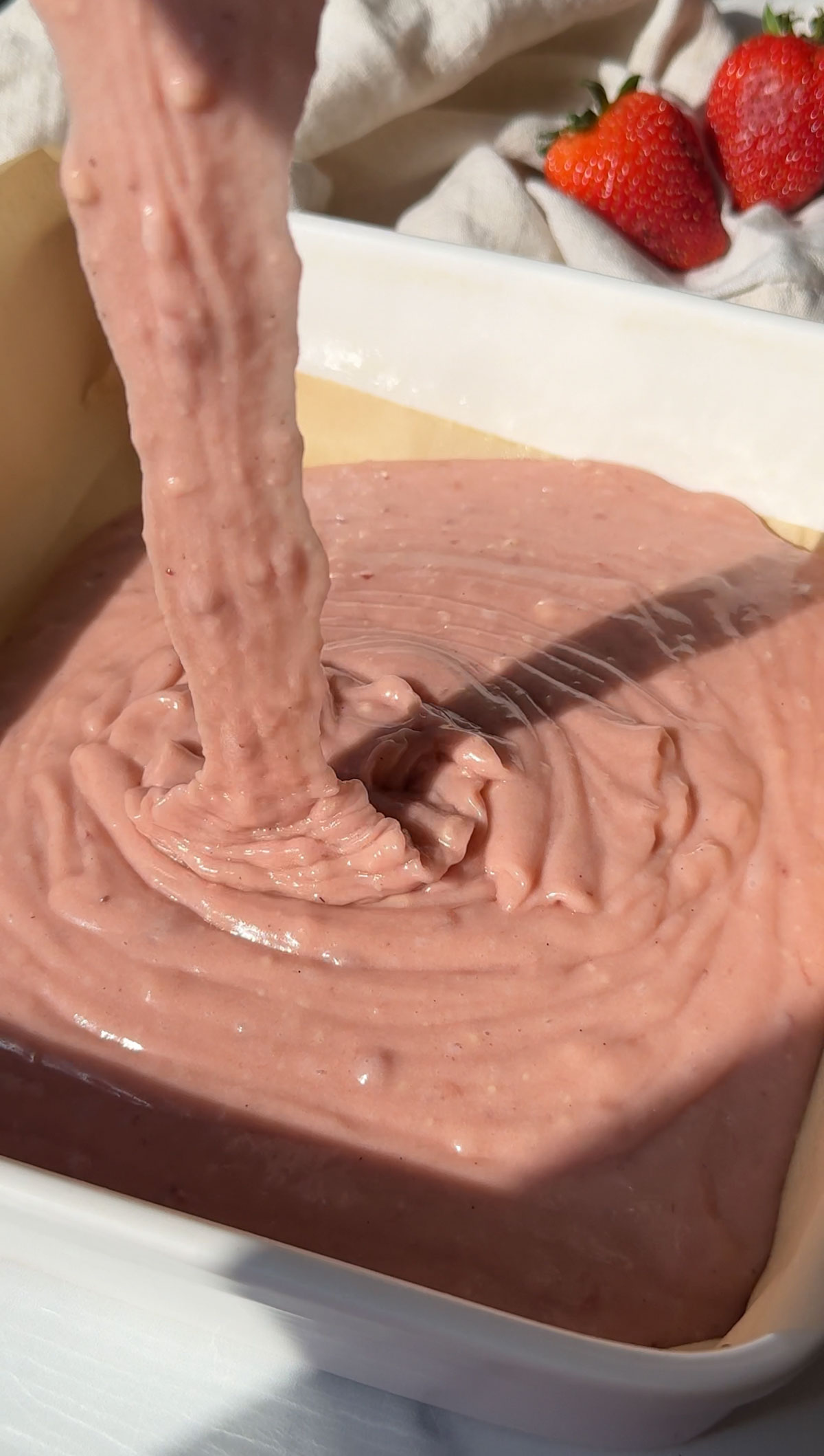 Transferring the cake batter to a baking dish.