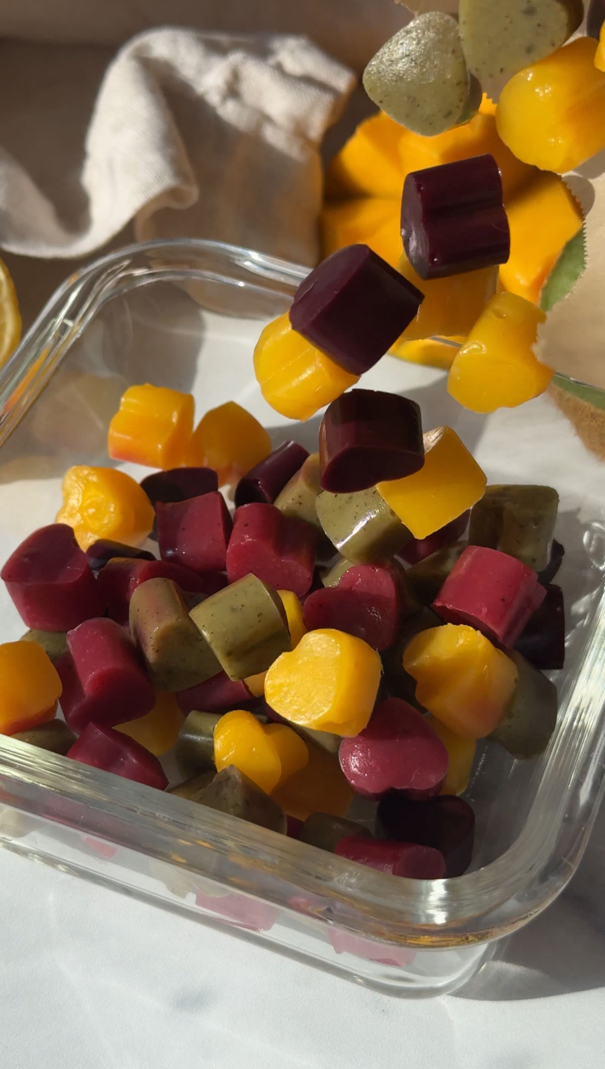 Pouring vegan gummies into a glass container.