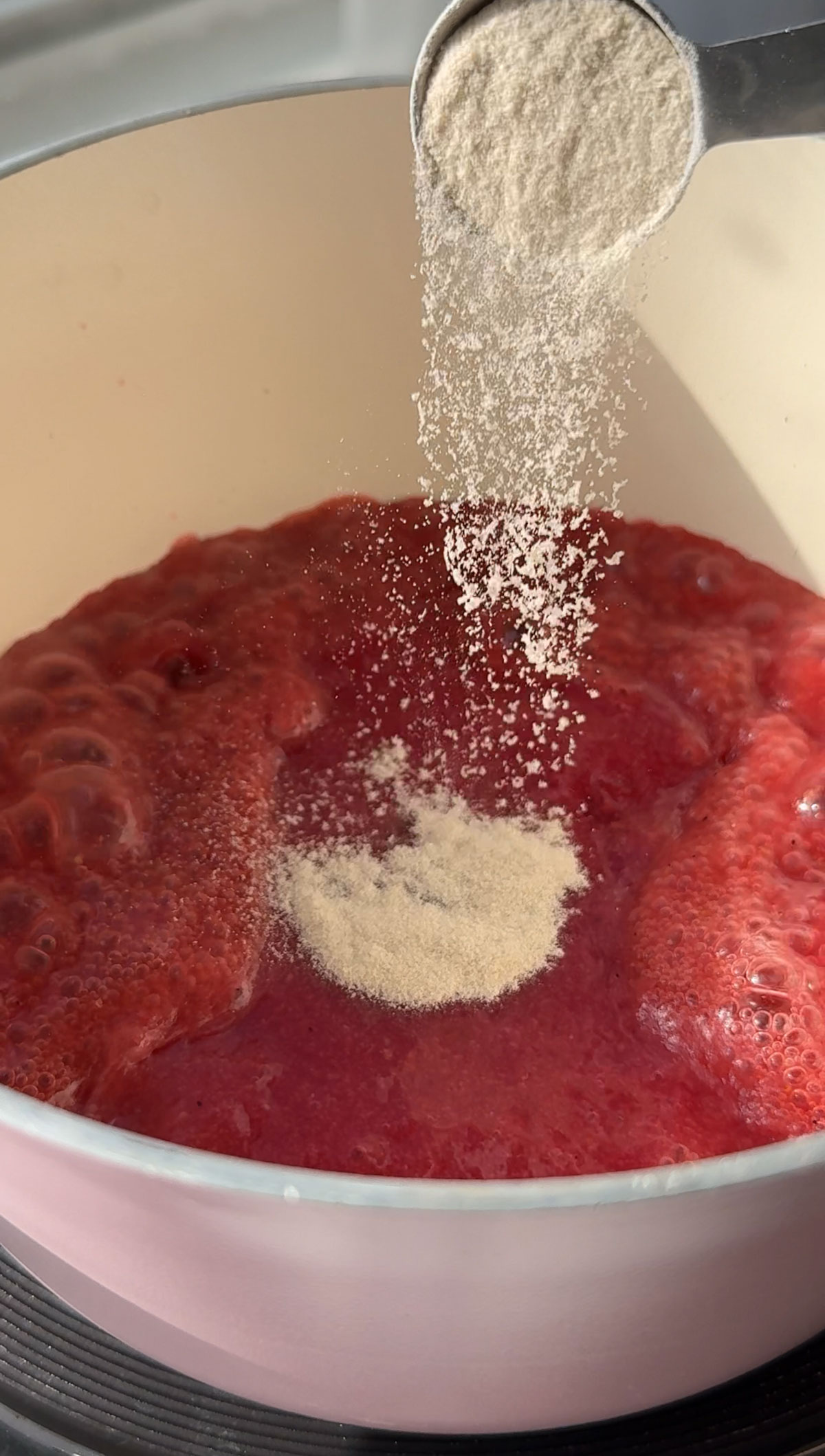 Adding the agar agar to the fruit puree in a pot.