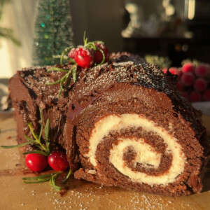 A vegan yule log recipe on a wood slice.