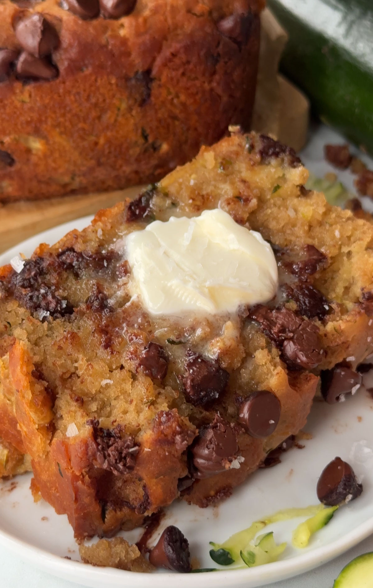 A slice of vegan zucchini bread topped with butter.