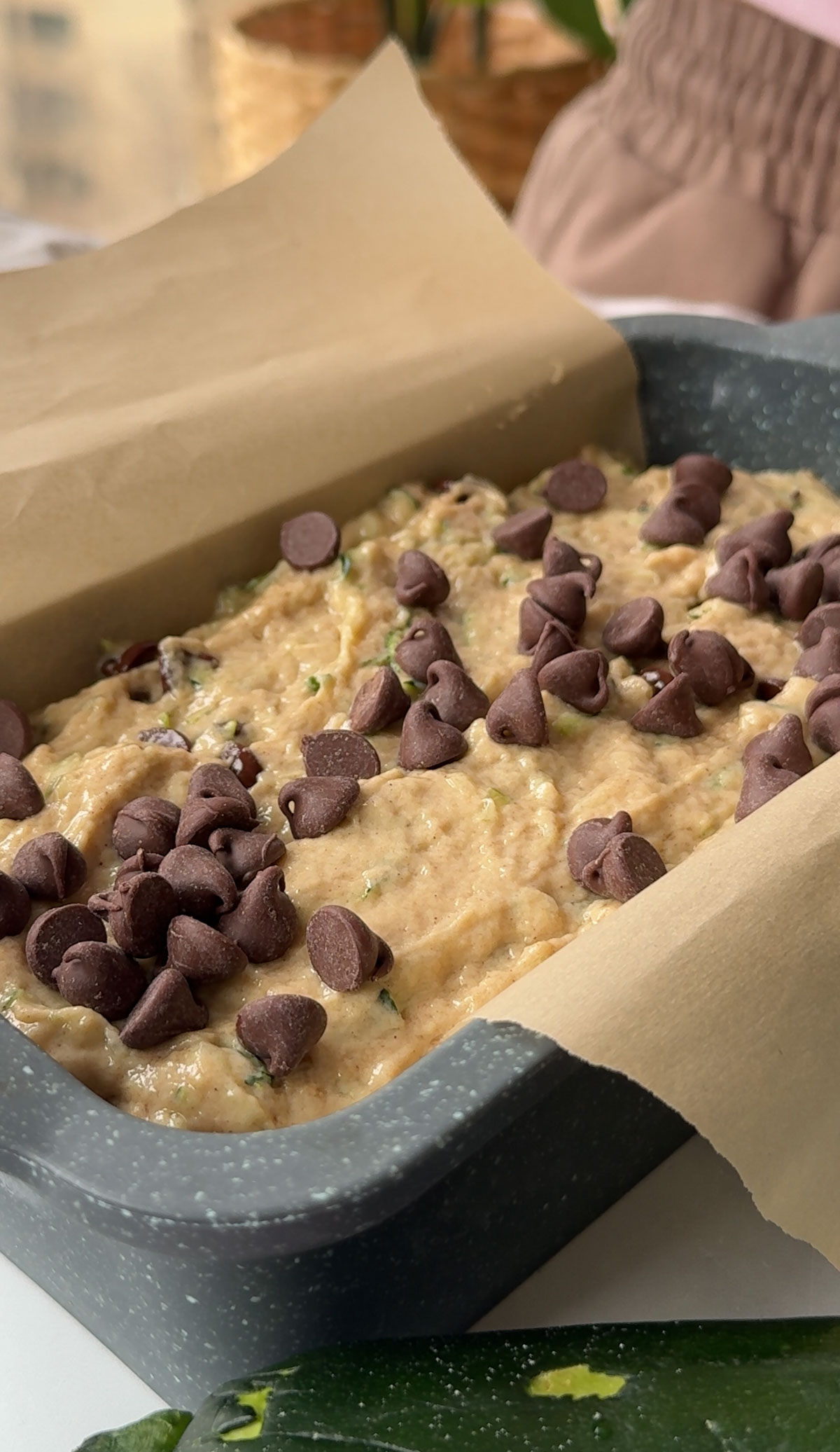 Zucchini bread without eggs poured into a parchment lined baking pan.
