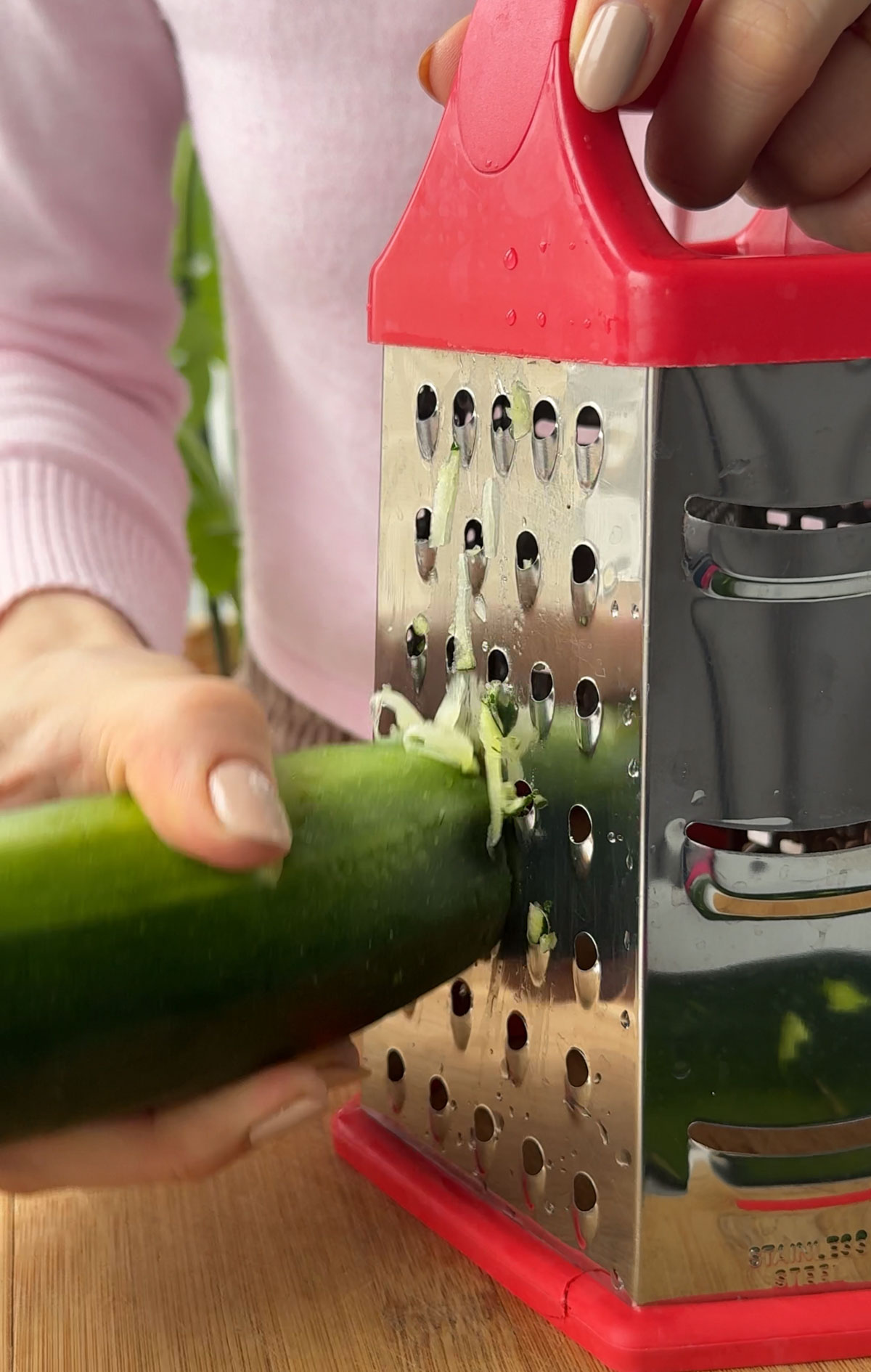 Grating zucchini to make vegan zucchini bread.