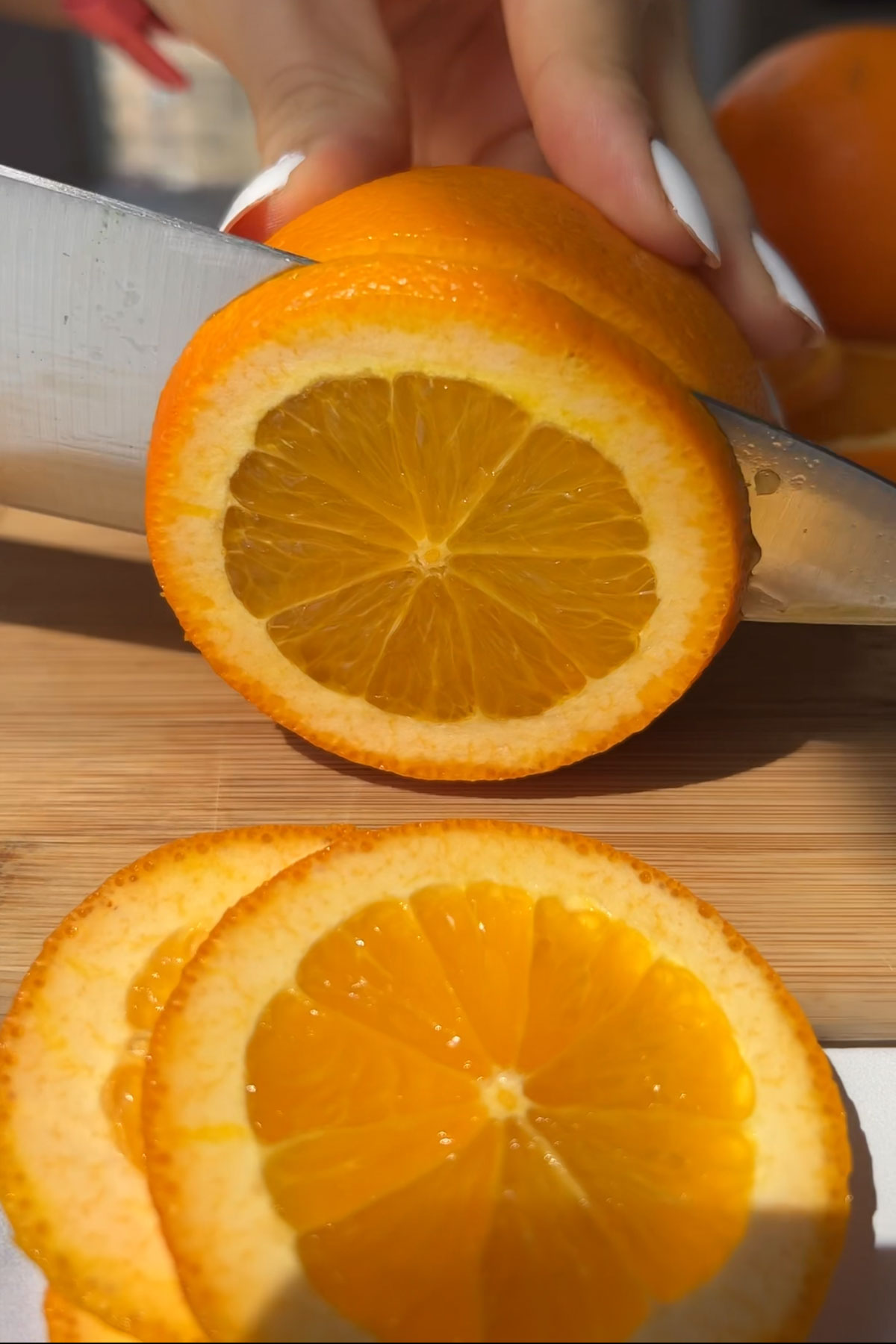 An orange being cut into slices.