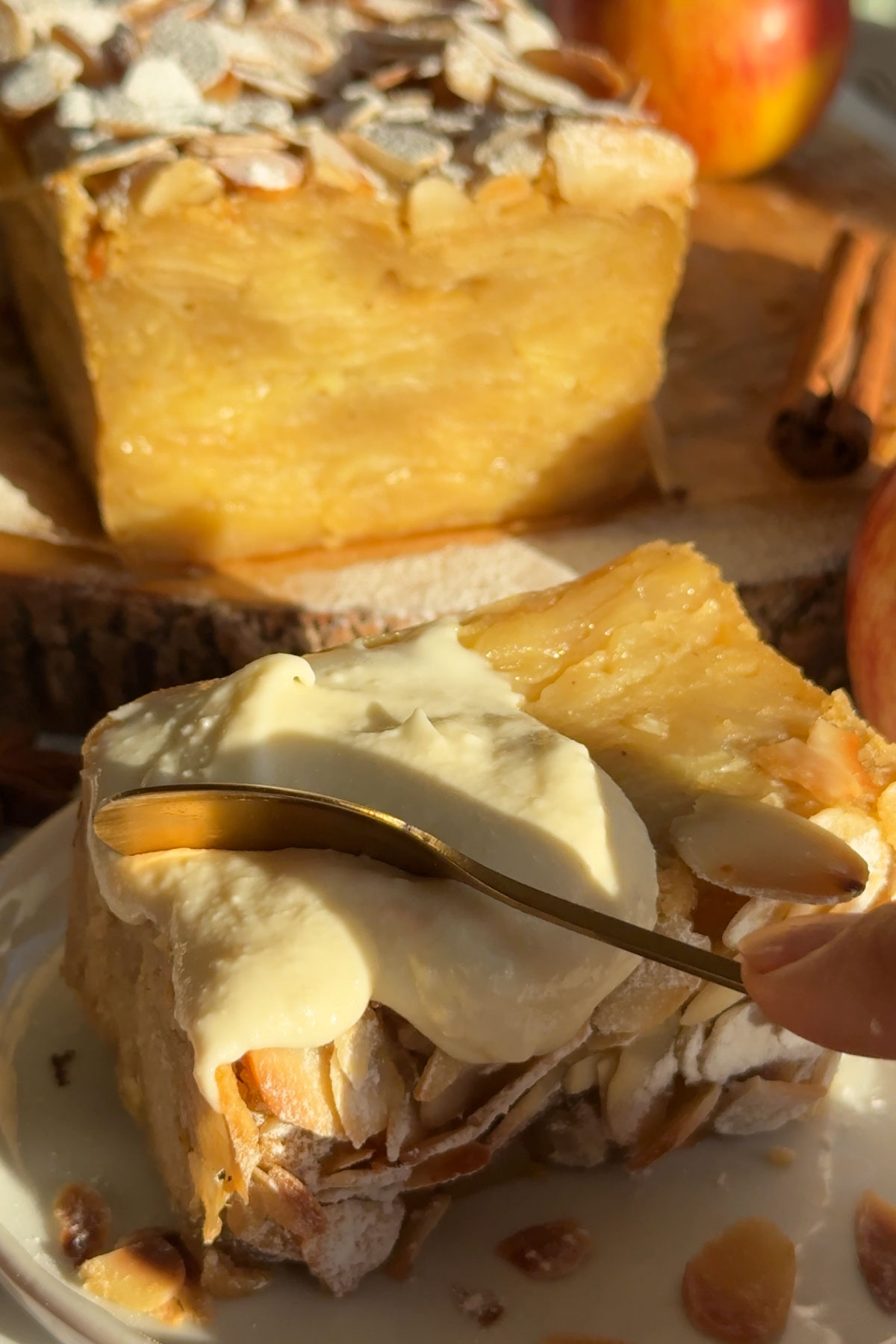 A spoon taking a piece of apple cake.