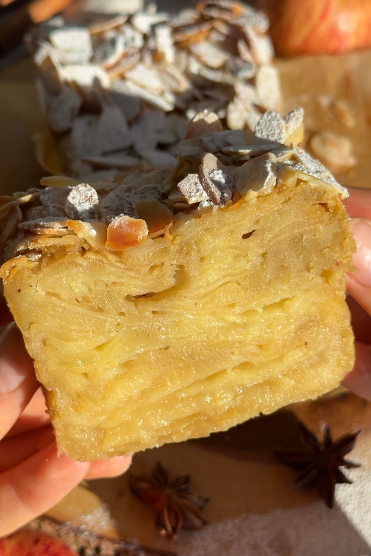 The apple cake being held up in the air.