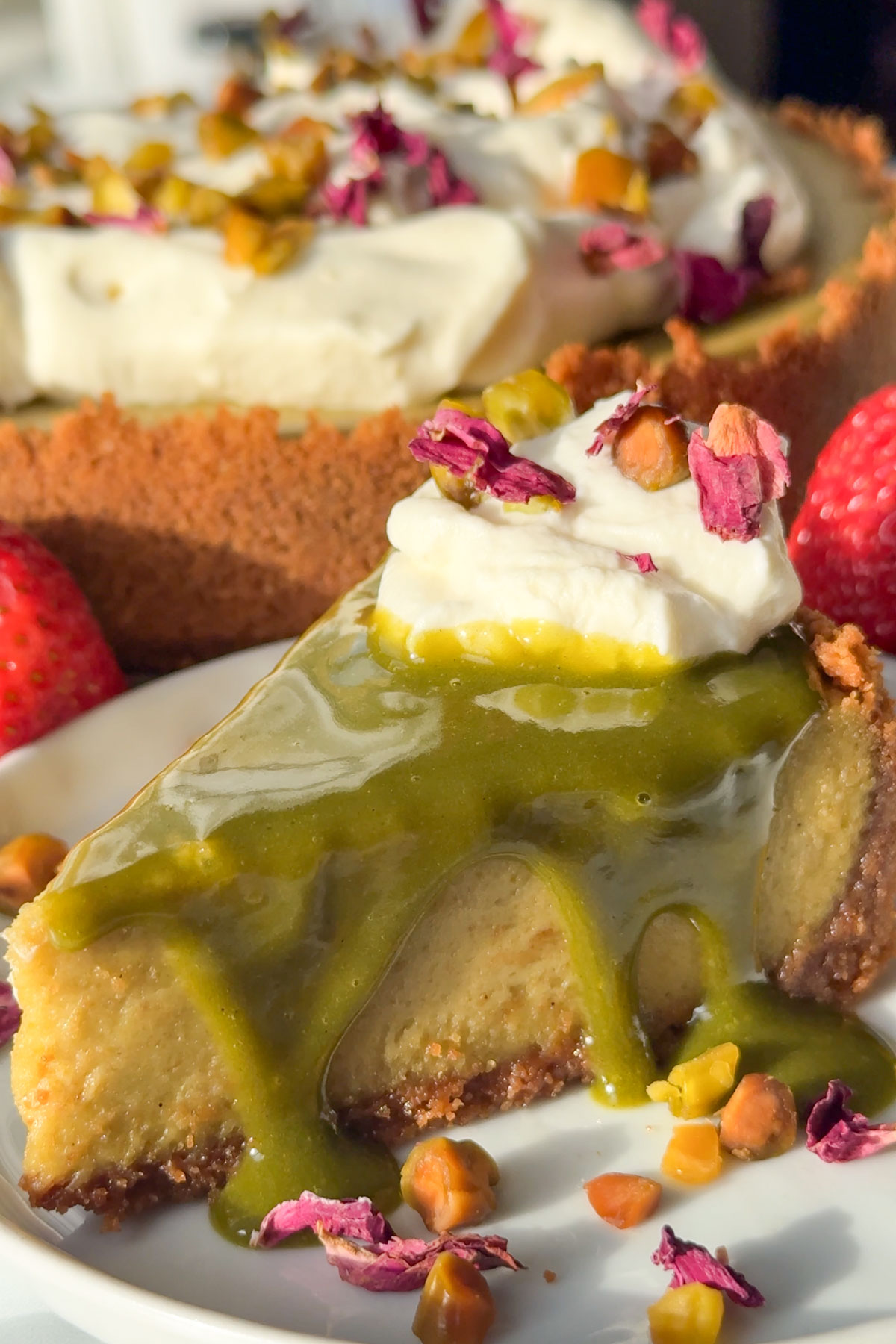 Pistachio cheesecake with sauce and whipped cream.