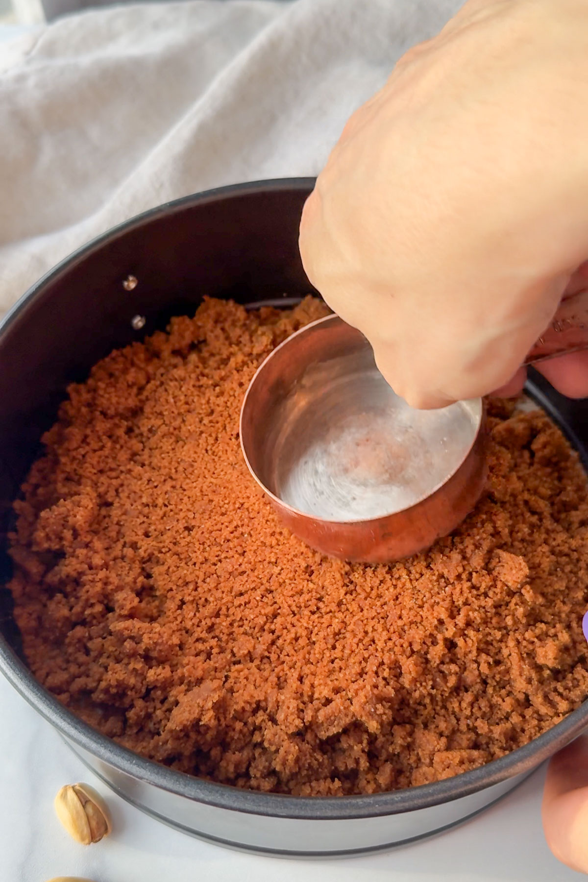 Crumbled cookies pushed to the bottom of the springform pan.