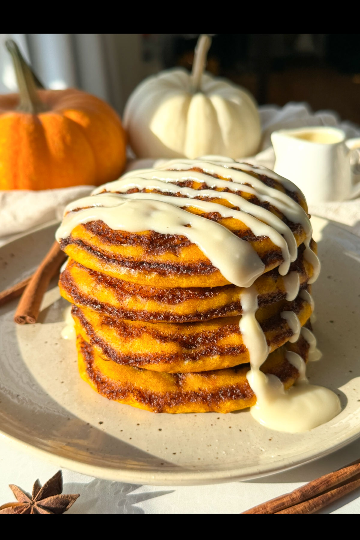 Pumpkin cinnamon roll pancakes on a plate.