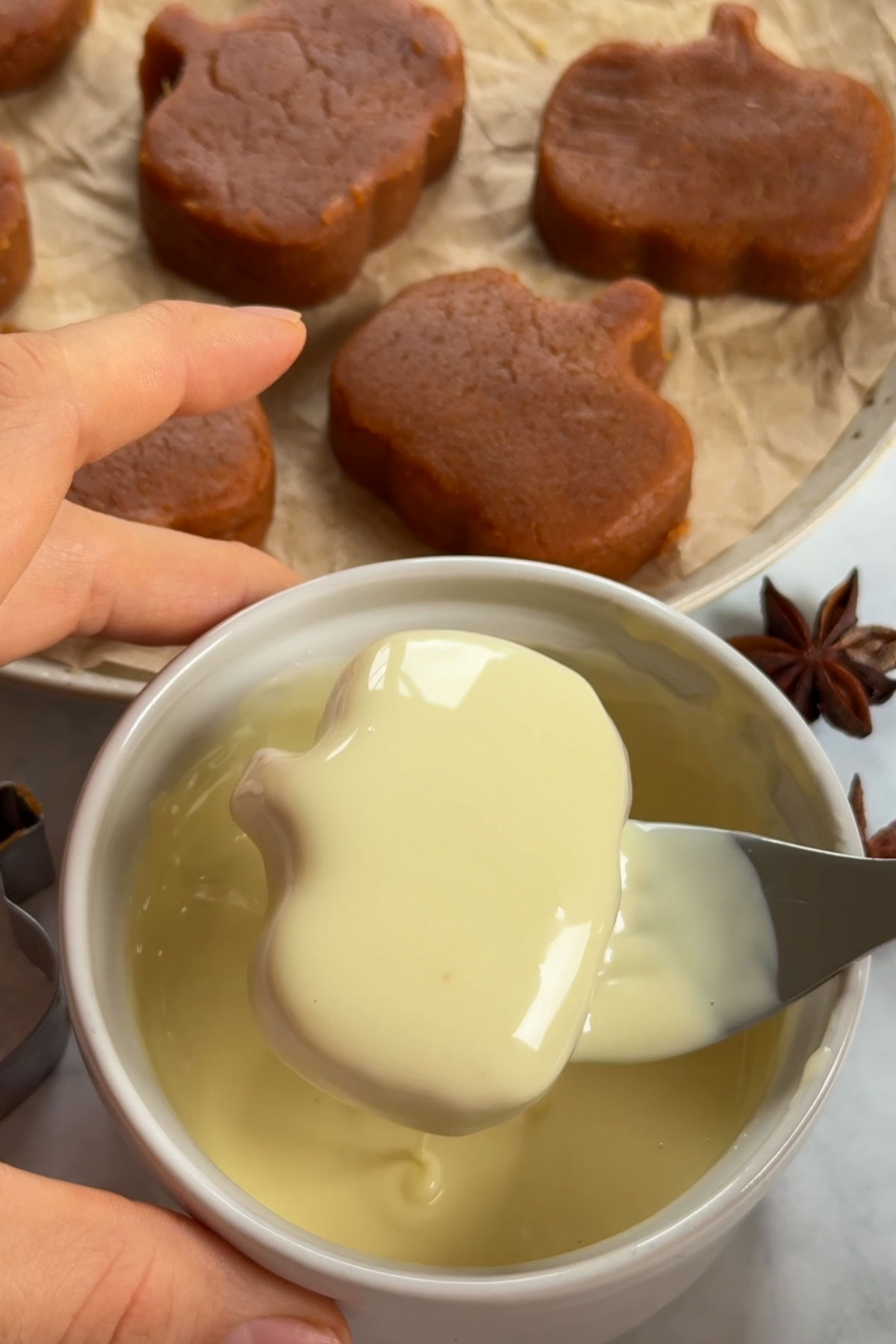 The dough being dipped into the white chocolate.