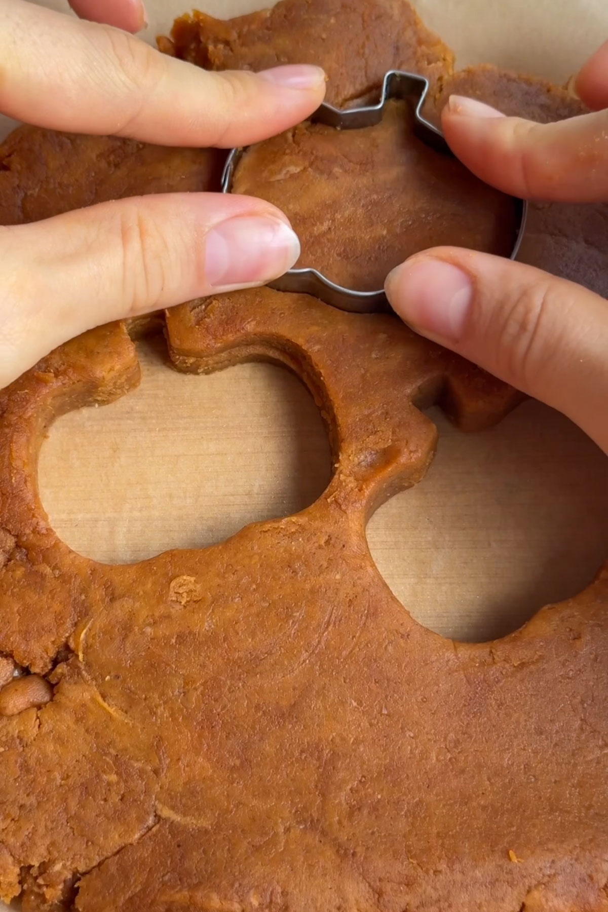 A pumpkin shaped cookie cutter making pump[kin shapes.