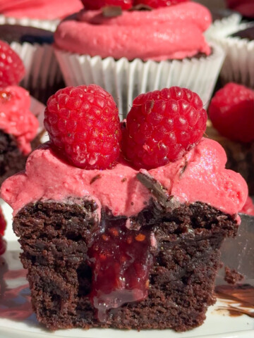 The inside of raspberry chocolate cupcakes cut open on a plate.