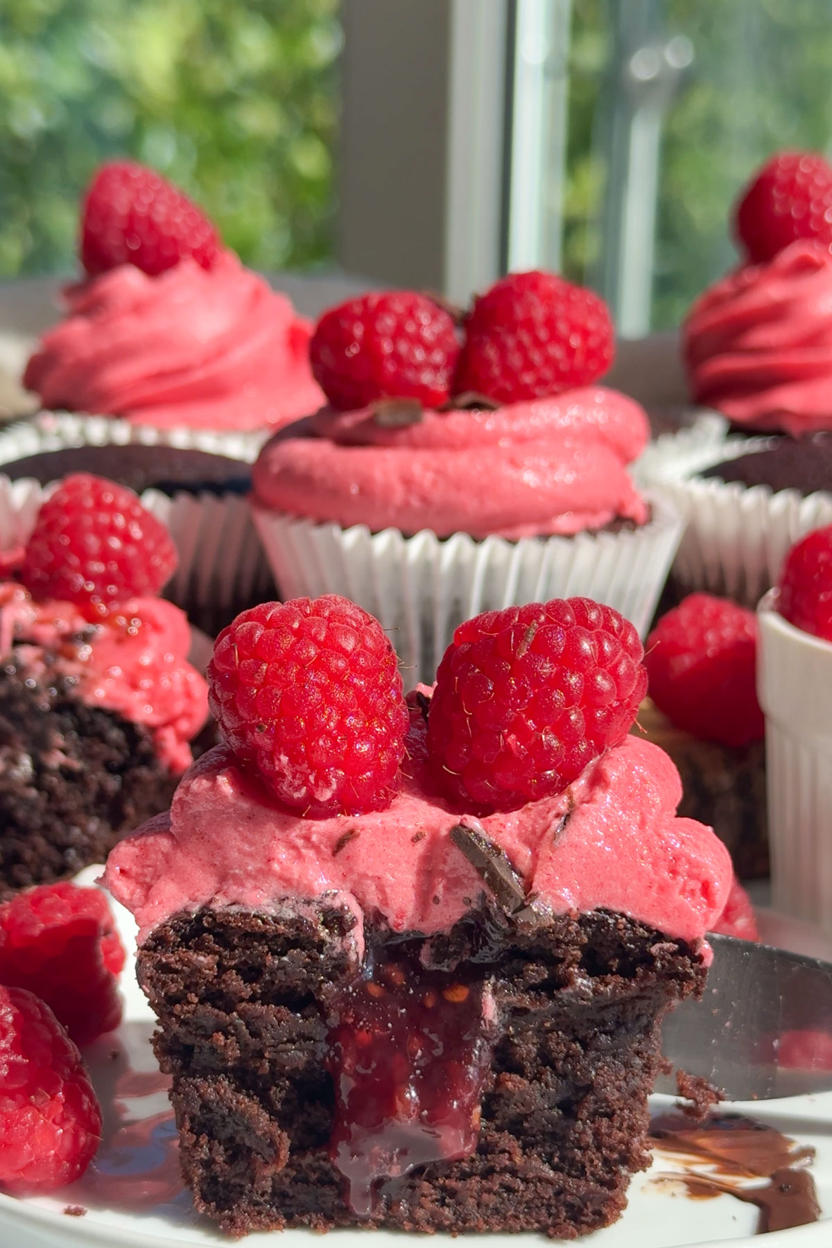 Raspberry chocolate cupcakes on a plate.