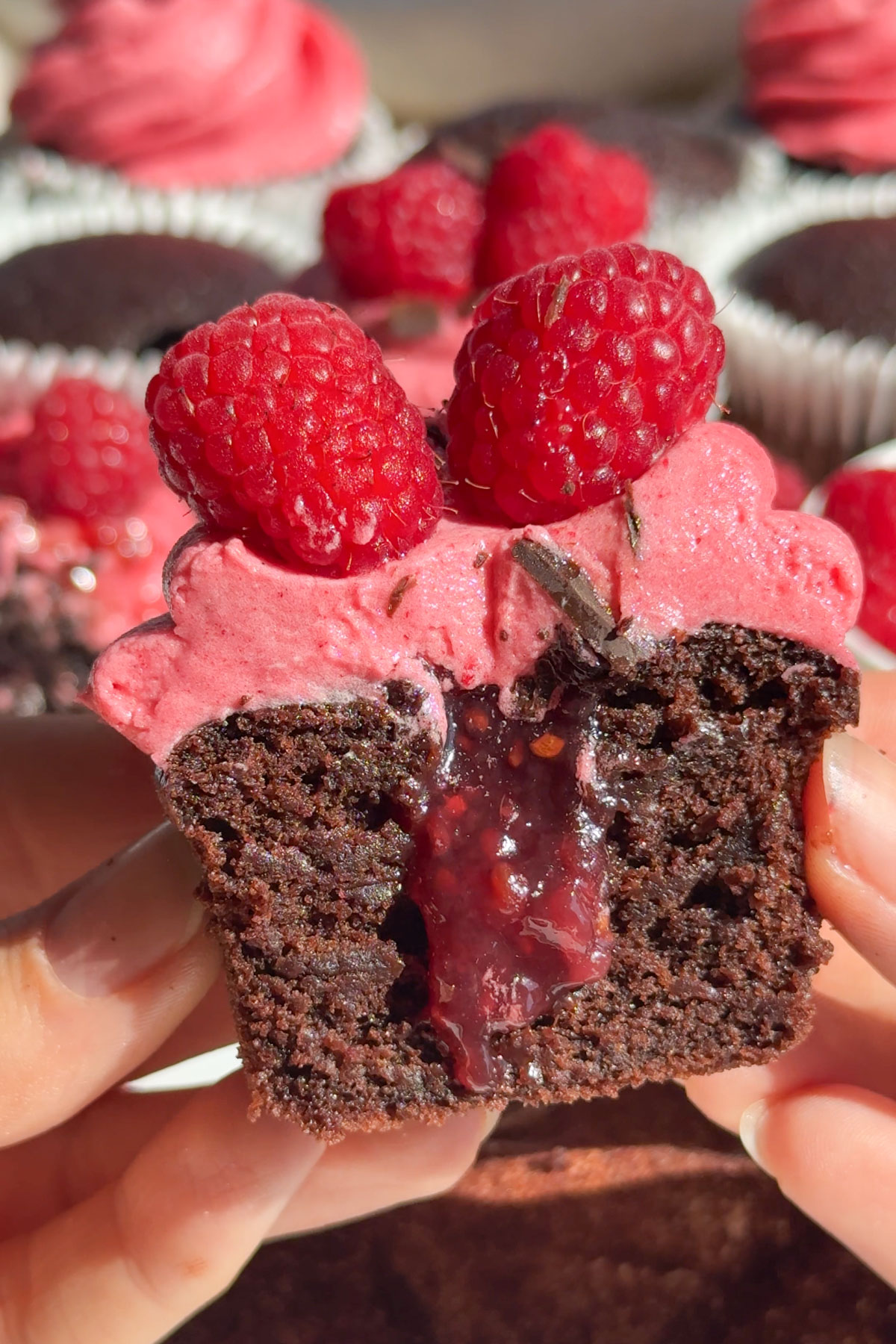 Chocolate cupcakes with raspberry in the center oozing out.