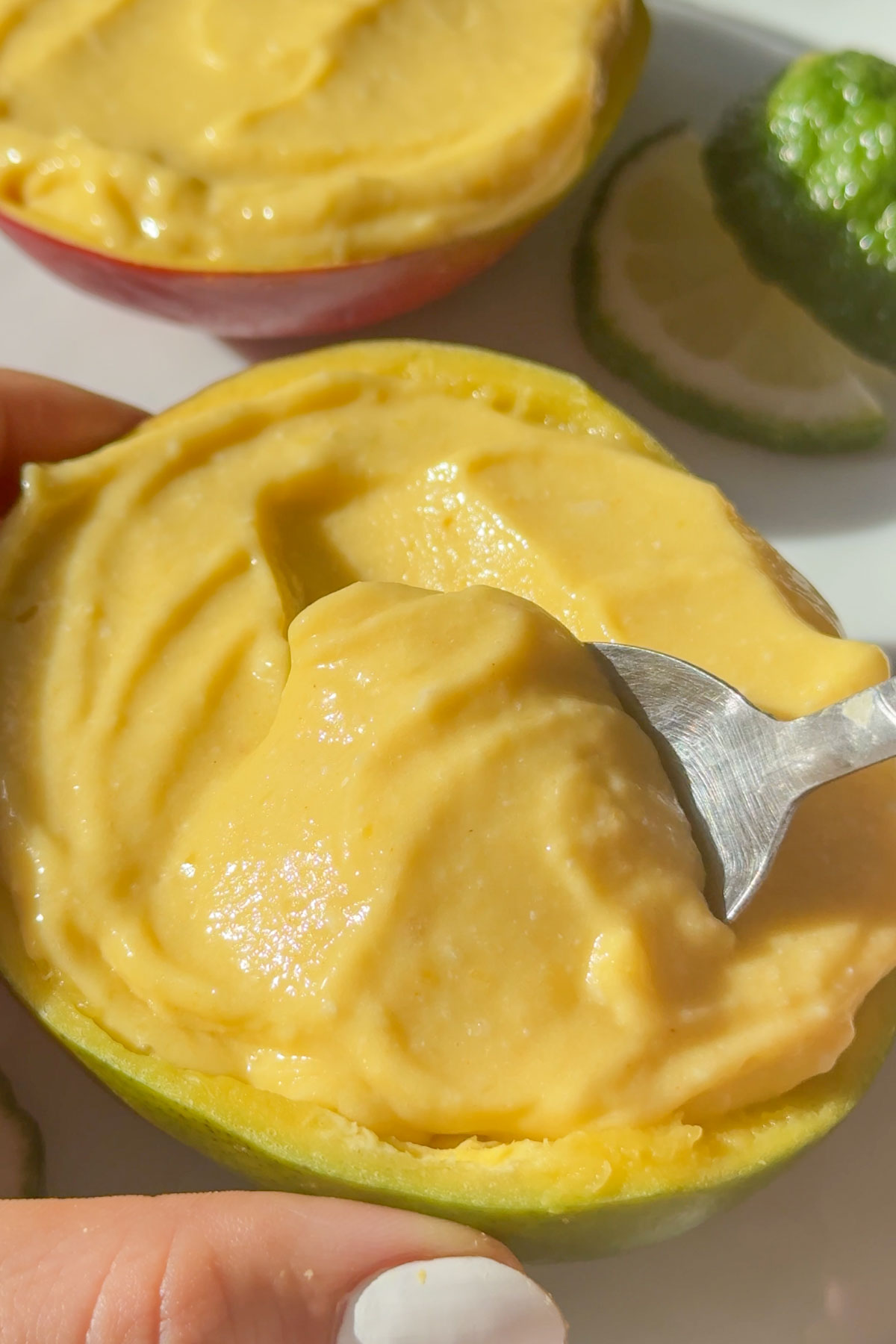 A spoon dipping into a vegan mango ice cream.