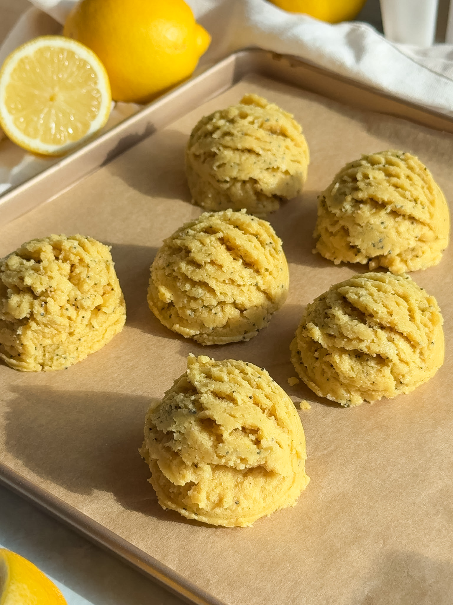 Dough balls on parchment paper lined baking sheet.