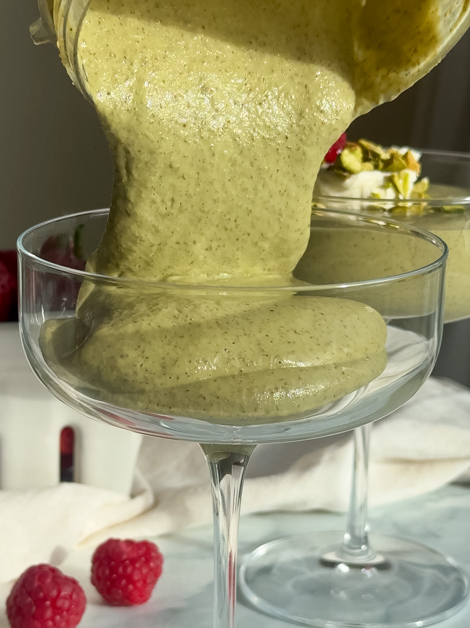 Blended chia pudding being poured into a glass.