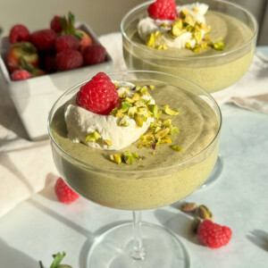 A glass with chia pudding with pistachio on top.