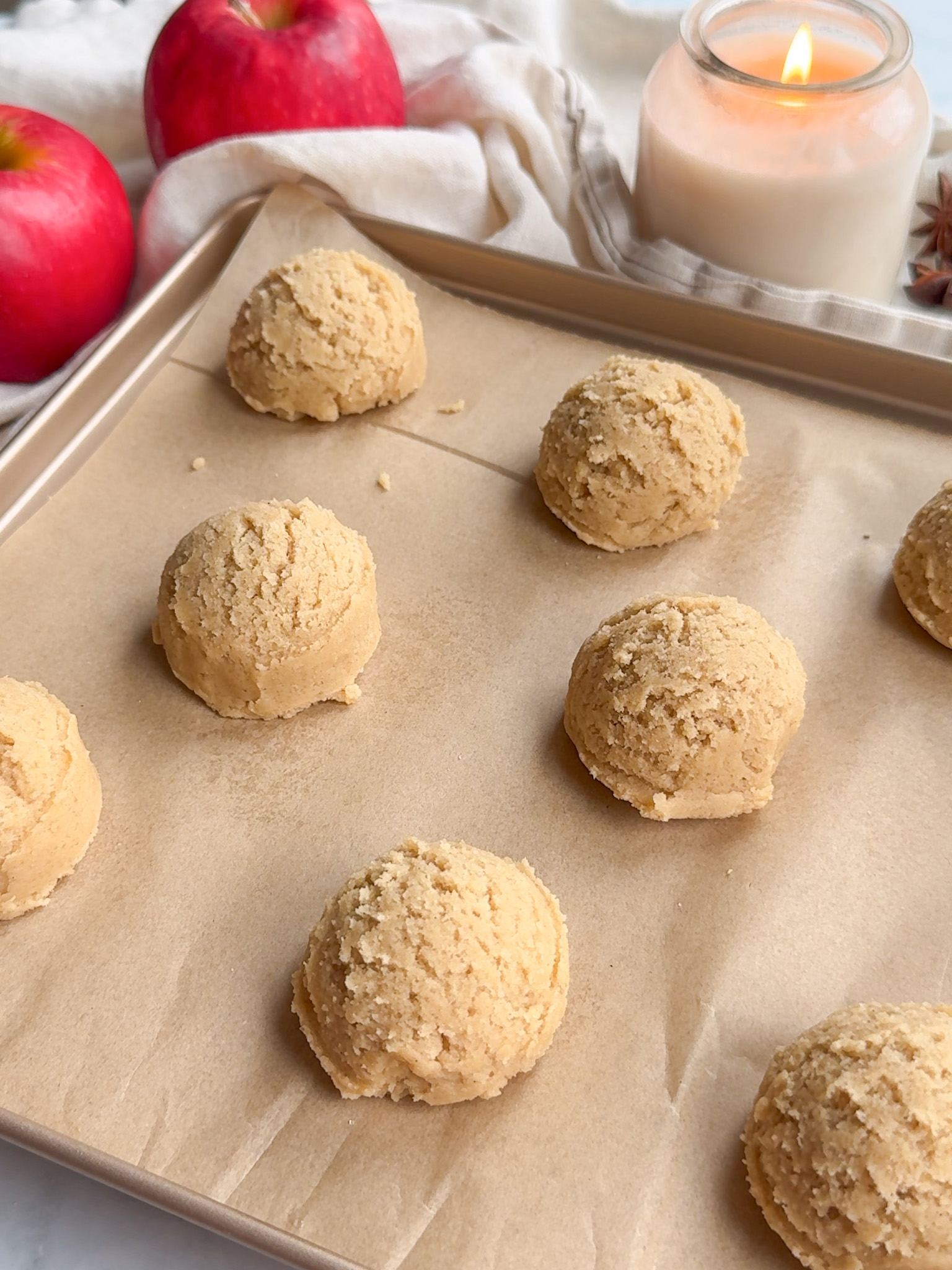 The cookie dough scooped on the parchment paper.